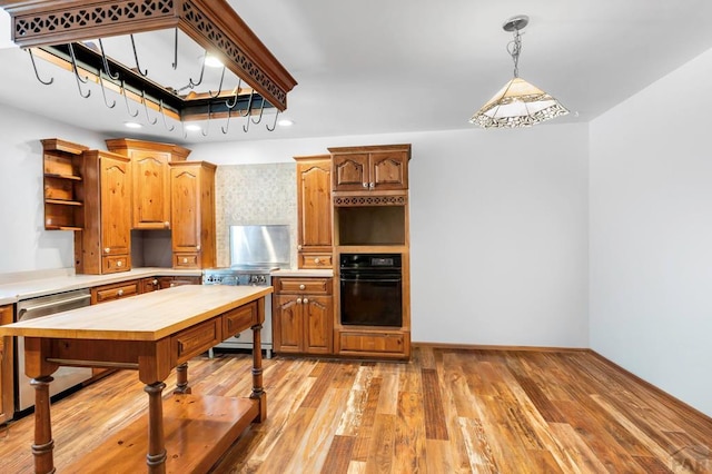 kitchen featuring dishwasher, pendant lighting, oven, light countertops, and open shelves