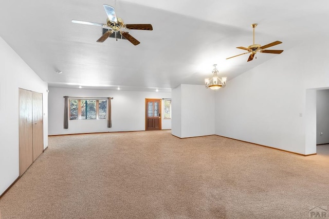 unfurnished living room with lofted ceiling, light colored carpet, and ceiling fan with notable chandelier