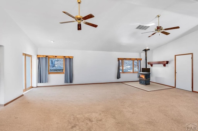 unfurnished living room featuring high vaulted ceiling, light carpet, visible vents, a ceiling fan, and a wood stove