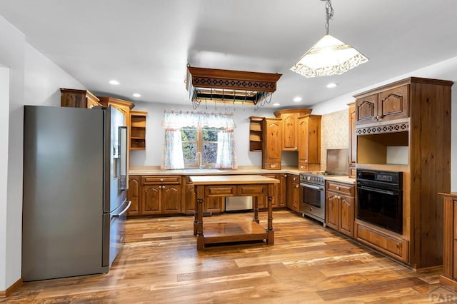 kitchen featuring stainless steel appliances, a sink, hanging light fixtures, light countertops, and open shelves