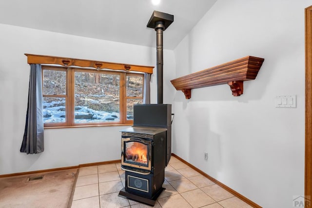 room details with visible vents, a wood stove, and baseboards