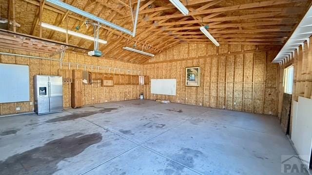 1326 E River St, Pueblo, CO 81001 - garage with stainless steel fridge with ice dispenser and a garage door opener