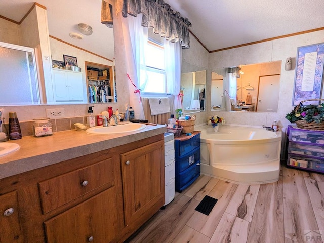 full bath with a sink, wood finished floors, and crown molding