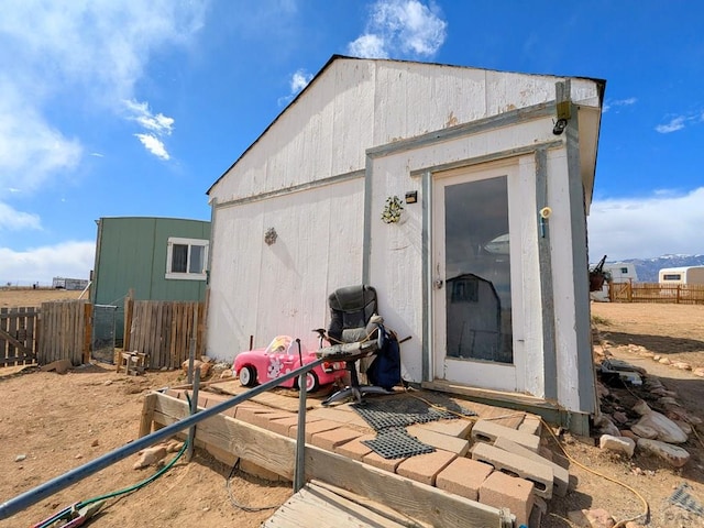 view of outbuilding featuring an outdoor structure and fence