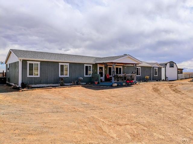 rear view of house with a shingled roof