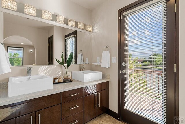 full bathroom with tile patterned flooring, a sink, and double vanity