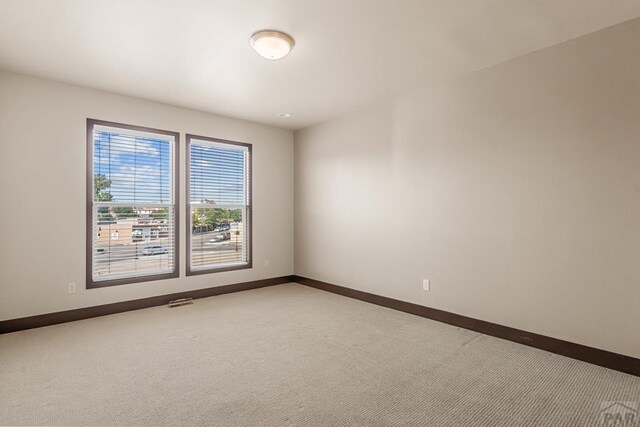 carpeted empty room with baseboards