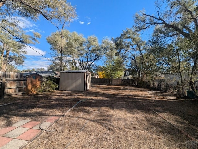 view of yard with an outbuilding, a fenced backyard, and a shed