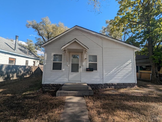 bungalow-style home with fence