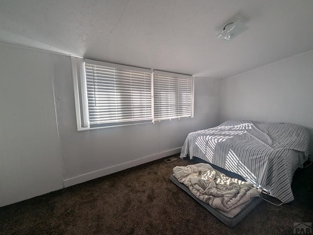 bedroom featuring dark colored carpet, visible vents, baseboards, and multiple windows