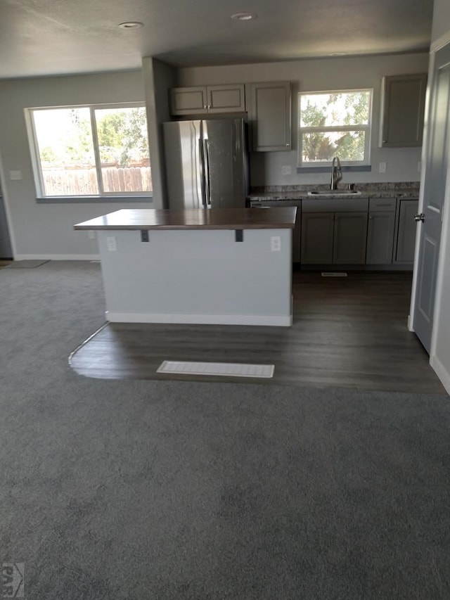 1708 W 8th St, Las Animas, CO 81054 - kitchen with freestanding refrigerator, gray cabinetry, a center island, and plenty of natural light