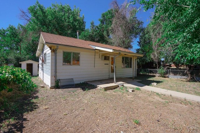 1021 7th St, Walsenburg, CO 81089 - view of front of property with a shed, fence, a patio, and an outbuilding