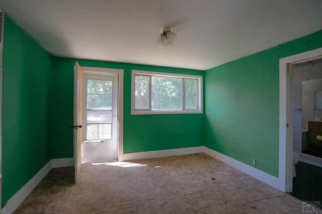 carpeted spare room with baseboards