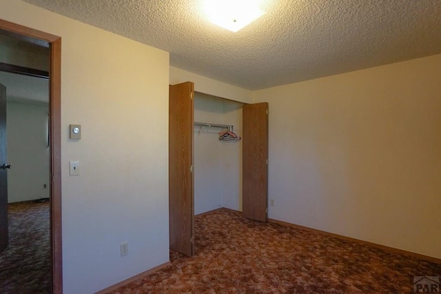 unfurnished bedroom with a textured ceiling, a closet, and carpet flooring