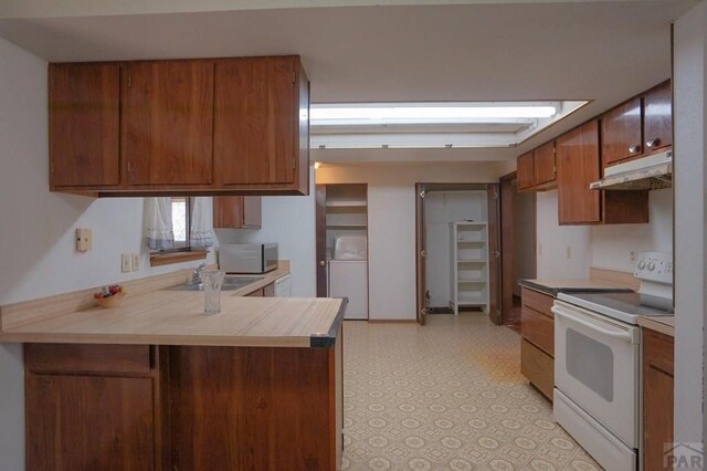 kitchen featuring white electric range oven, light countertops, stainless steel microwave, a peninsula, and under cabinet range hood