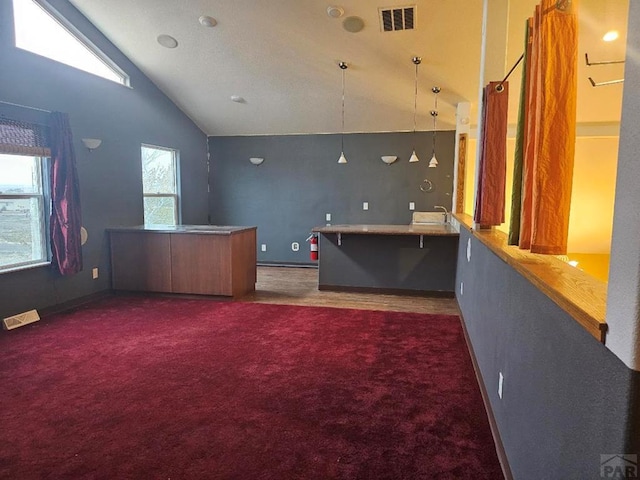 interior space with dark colored carpet, visible vents, and baseboards