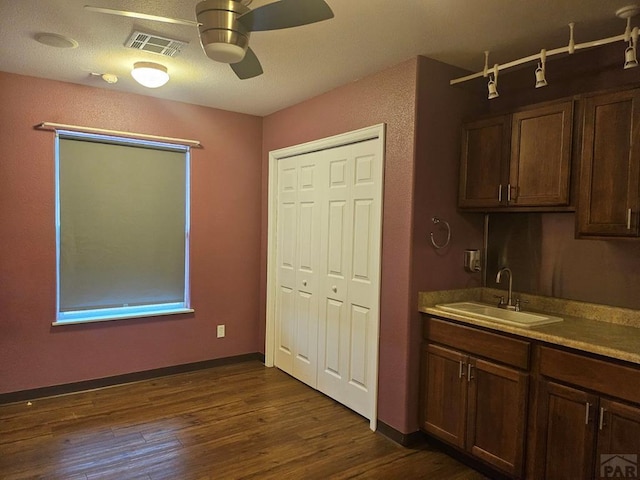 interior space with dark brown cabinetry, visible vents, ceiling fan, dark wood-style flooring, and a sink