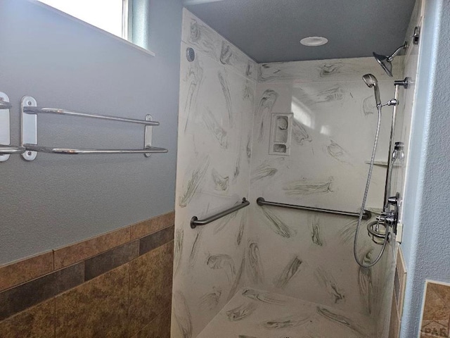 bathroom featuring a marble finish shower