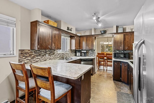 36 Loyola Ln, Pueblo, CO 81005 - kitchen featuring stainless steel appliances, a sink, dark brown cabinets, light countertops, and a peninsula
