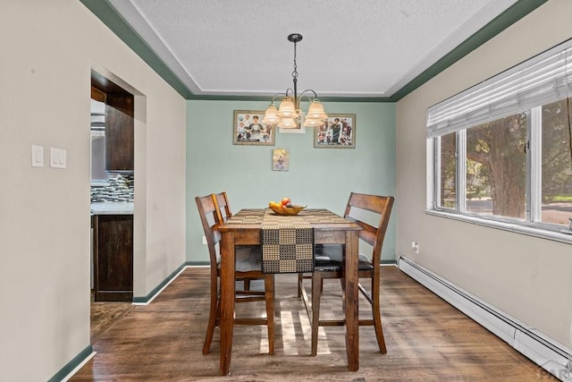 36 Loyola Ln, Pueblo, CO 81005 - dining area with baseboard heating, a chandelier, wood finished floors, a textured ceiling, and baseboards