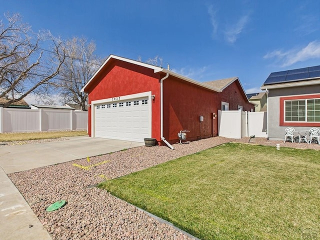 view of home's exterior featuring stucco siding, a lawn, driveway, fence, and an attached garage