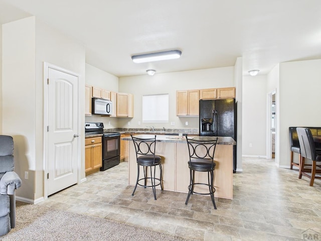 kitchen featuring light brown cabinets, baseboards, a breakfast bar, black appliances, and a center island