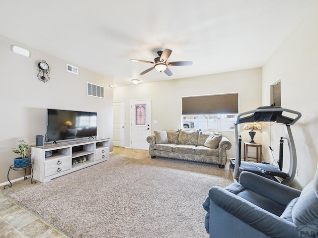 living room featuring visible vents, carpet flooring, baseboards, and a ceiling fan