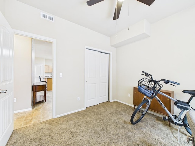 exercise room featuring visible vents, carpet floors, baseboards, and ceiling fan