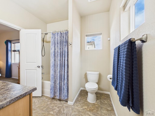 full bath with a wealth of natural light, shower / bath combination with curtain, toilet, and vanity