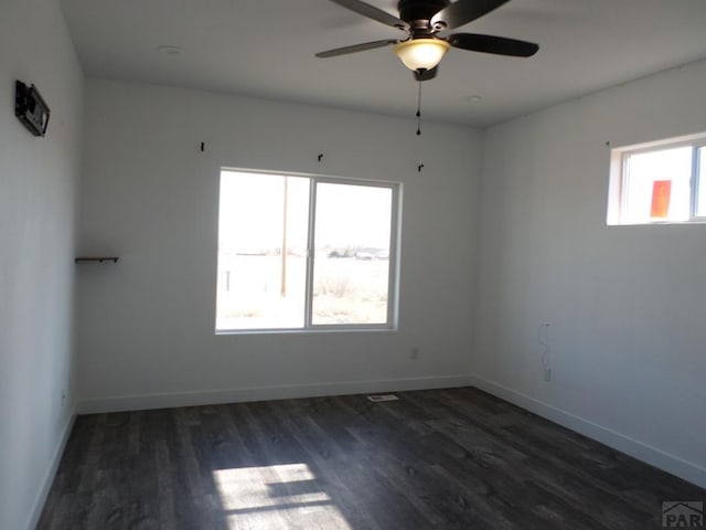 spare room with a ceiling fan, wood finished floors, and baseboards