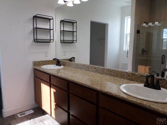 full bathroom with a shower stall, toilet, visible vents, and a sink