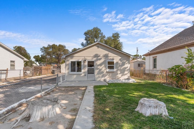 back of house featuring a fenced backyard, a lawn, and a patio