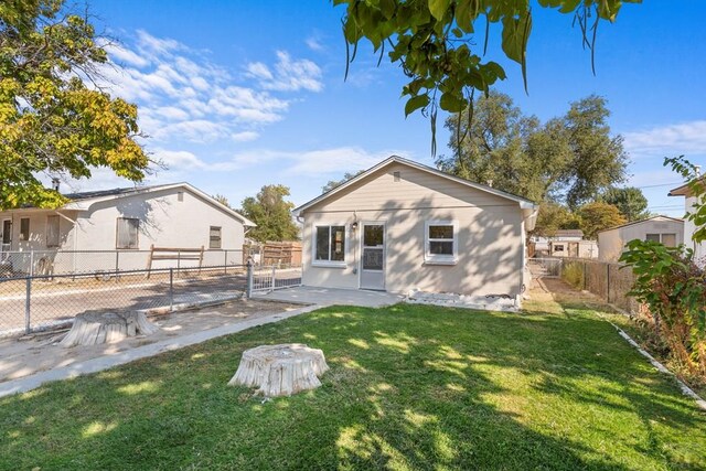 back of house featuring a lawn and a fenced backyard