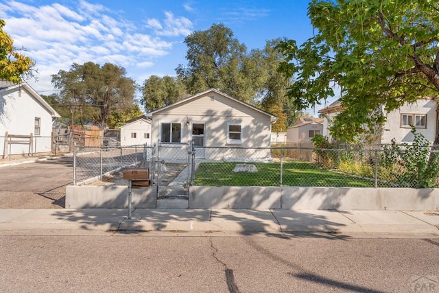 view of front facade with a front lawn, a fenced front yard, and a gate