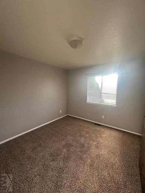 662 S Bayfield Ave, Pueblo West, CO 81007 - spare room featuring baseboards and dark carpet