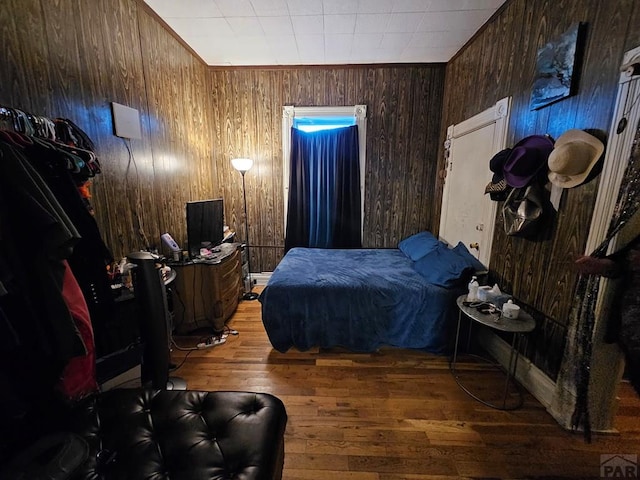 bedroom featuring wood walls and wood finished floors