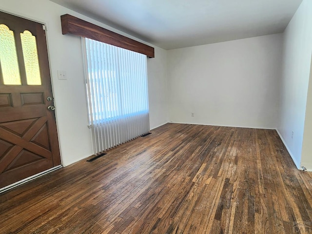 empty room featuring dark wood finished floors and visible vents