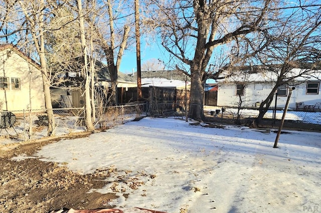 snowy yard featuring fence