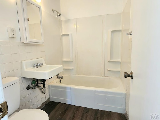 full bathroom featuring wood finished floors, shower / tub combination, toilet, and tile walls