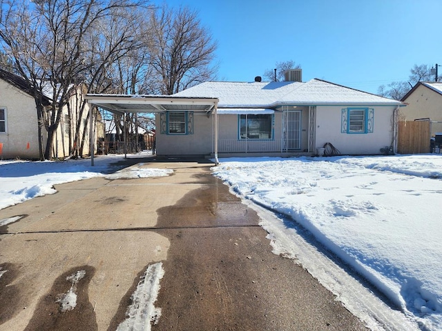 ranch-style home with an attached carport, concrete driveway, and stucco siding