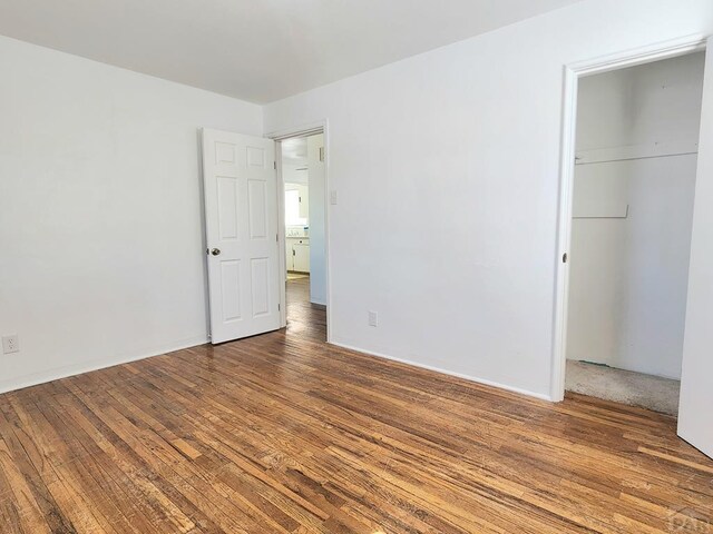 unfurnished bedroom featuring a closet and wood finished floors