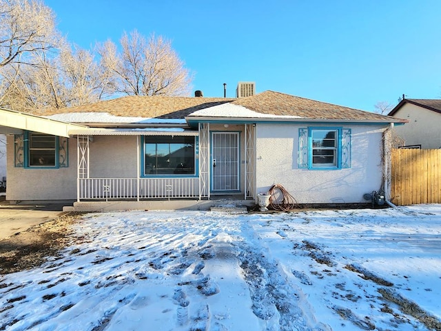 view of front of property featuring covered porch, fence, and stucco siding