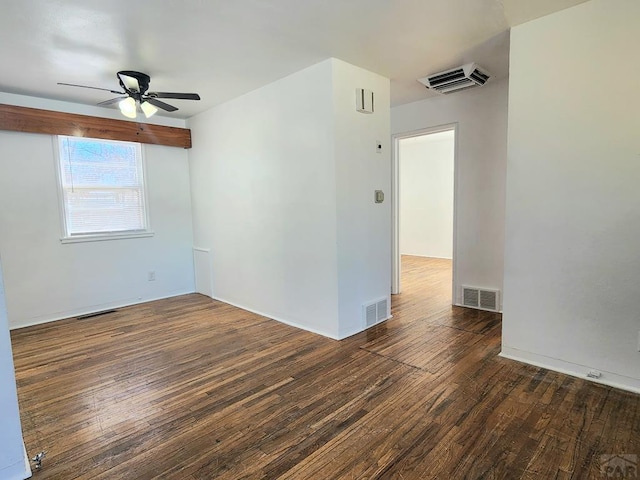 empty room with ceiling fan, visible vents, and dark wood finished floors