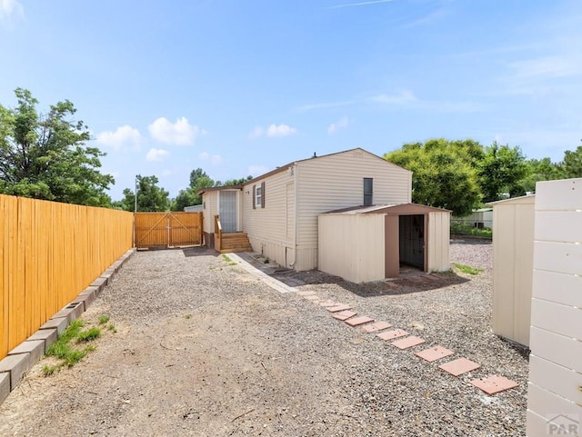 353 E Byrd Dr, Pueblo West, CO 81007 - rear view of property with a storage shed and a gate