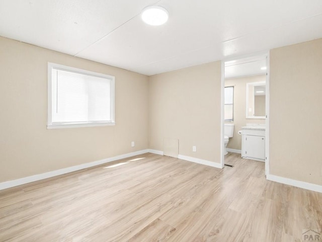 353 E Byrd Dr, Pueblo West, CO 81007 - unfurnished bedroom with light wood-type flooring, multiple windows, and connected bathroom