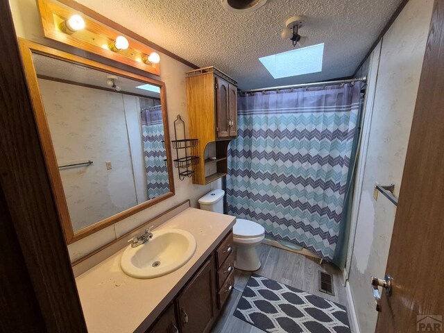 1106 10th St, Las Animas, CO 81054 - bathroom with a skylight, vanity, a textured ceiling, and curtained shower