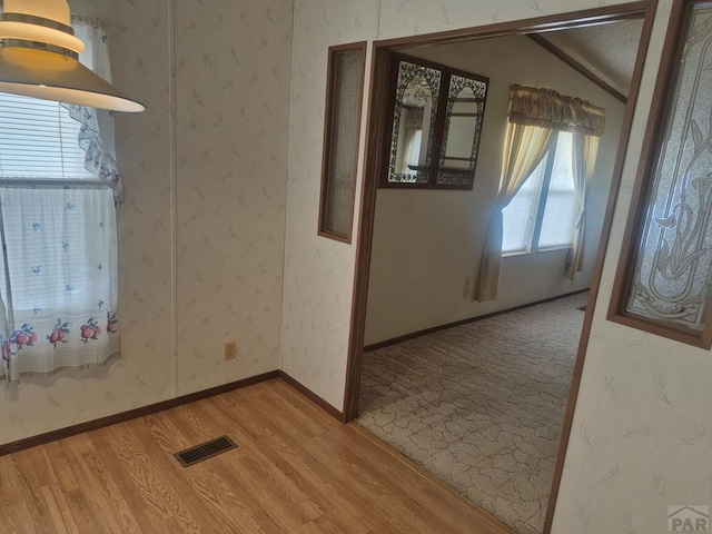 1106 10th St, Las Animas, CO 81054 - empty room featuring lofted ceiling, light wood finished floors, and wallpapered walls