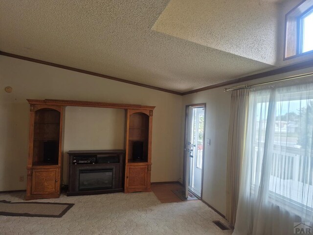 1106 10th St, Las Animas, CO 81054 - unfurnished living room featuring ornamental molding, a textured ceiling, and light colored carpet