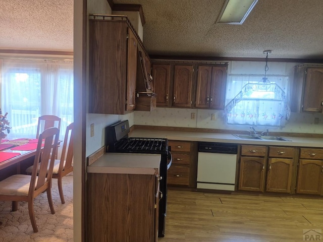 1106 10th St, Las Animas, CO 81054 - kitchen featuring dishwasher, range with gas stovetop, a textured ceiling, plenty of natural light, and light wood-style flooring