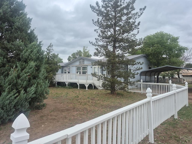 1106 10th St, Las Animas, CO 81054 - back of house featuring a detached carport and a deck